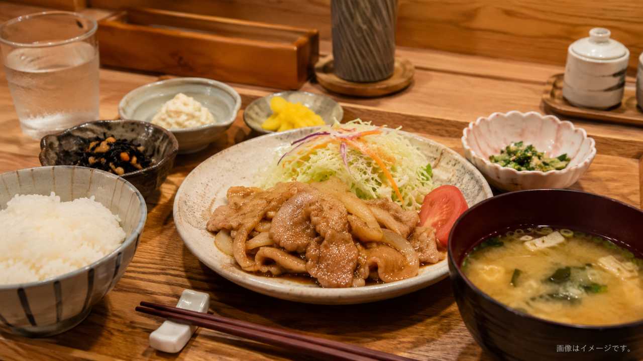 温かい照明の飲食店街とリーズナブルな定食を自然に配置したブログ用アイキャッチ