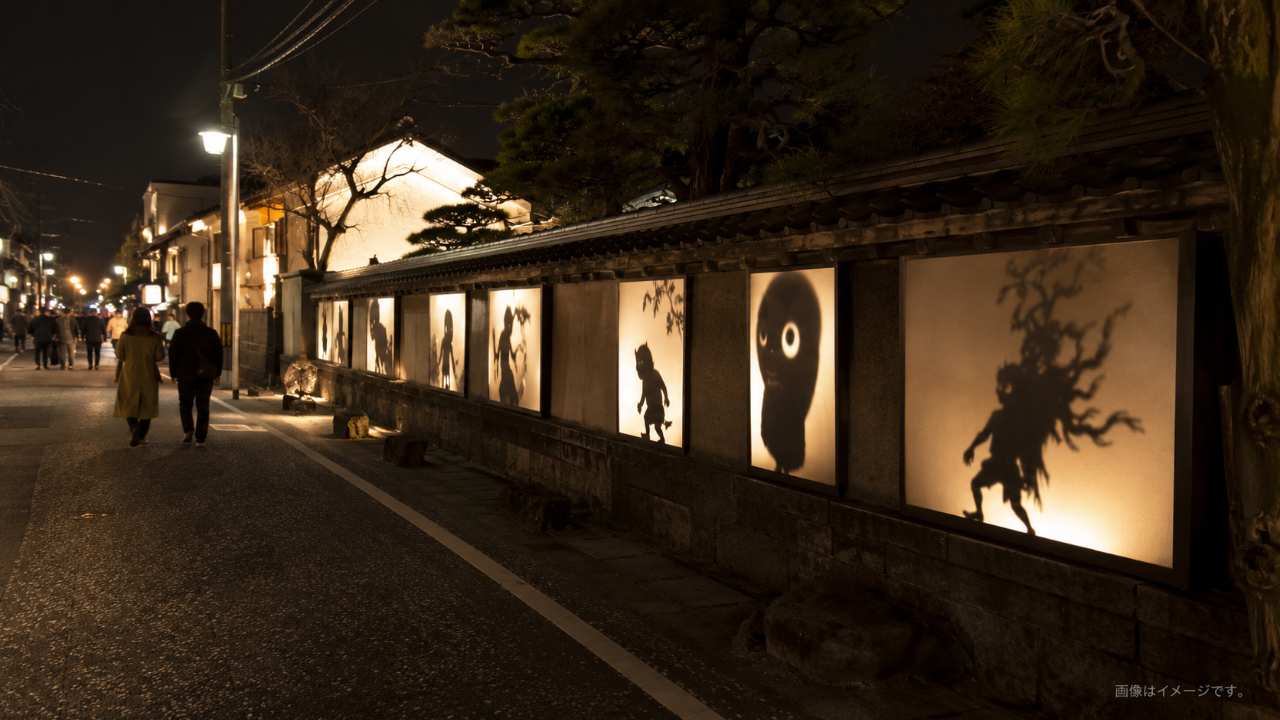 夜の水木しげるロードをイメージしたライトアップ風景、妖怪の影絵照明と幻想的な街歩き
