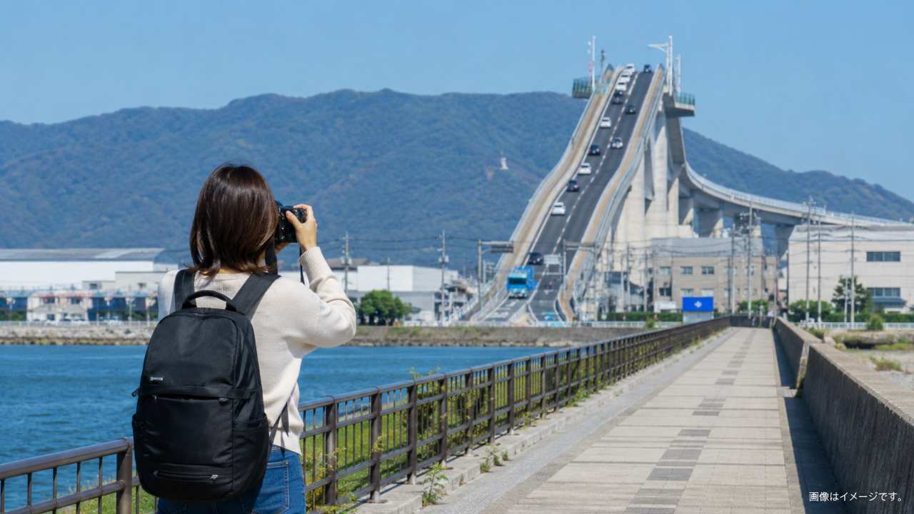 江島大橋を遠くから撮影する旅行者の後ろ姿