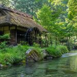 鳥取県米子市淀江町の名水スポットをイメージした、茅葺き屋根の水車小屋と透明な清流