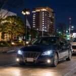 鳥取県の夜の街並みを背景に、安心感のある代行車と随伴車が落ち着いた雰囲気で並ぶ