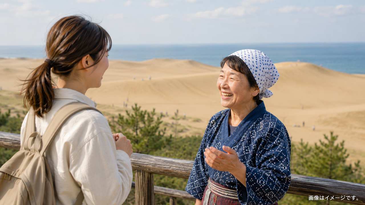 。鳥取砂丘を背景に、旅人が地元の人とやさしく会話しているブログ用アイキャッチ画像