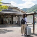倉吉駅構内でスーツケースを持った旅行者がコインロッカーの場所を確認する様子