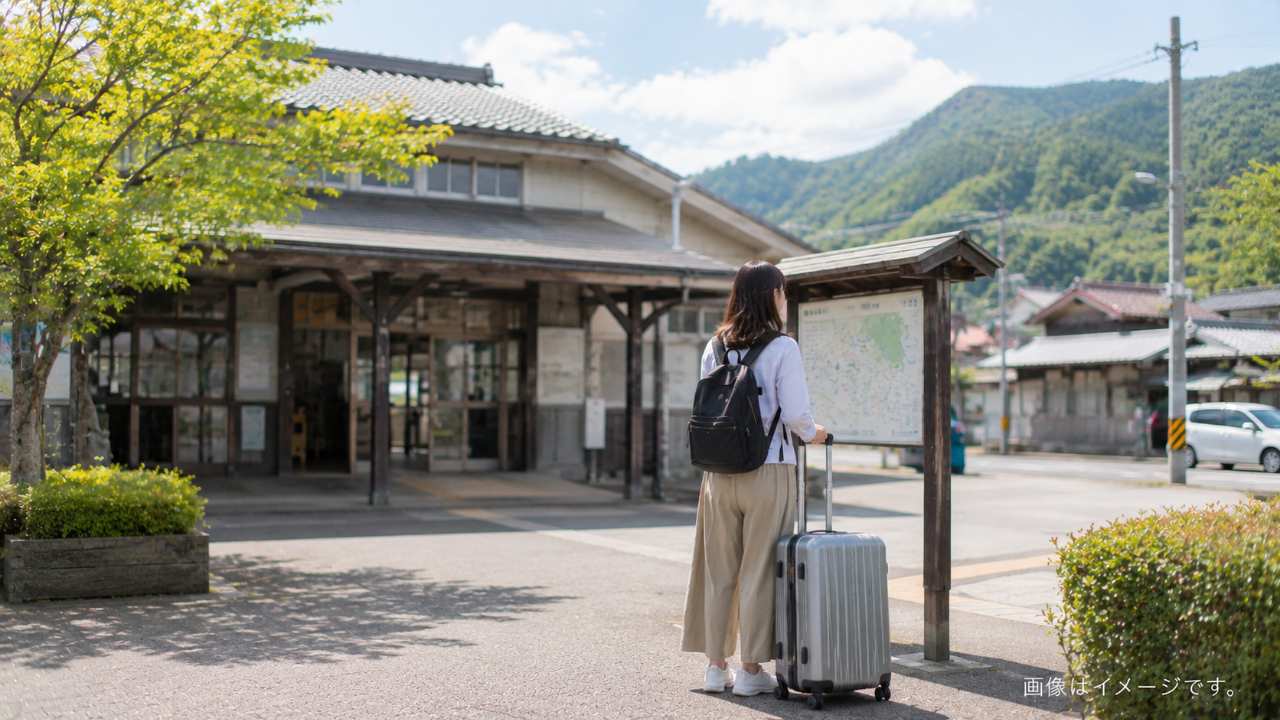 倉吉駅構内でスーツケースを持った旅行者がコインロッカーの場所を確認する様子