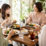 鳥取市の明るいカフェで友人同士がランチプレートを囲み会話を楽しむテーブル席